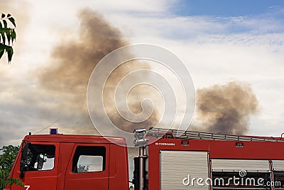 A fire brigade on a fire engine extinguishes a forest fire. Inscriptions on the car in Russian - fire truck and Odessa. 2019. 06. Editorial Stock Photo