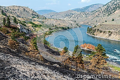 Fire damage near the railroad tracks running along the Thompson River near Spences Bridge in British Columbia, Canada Stock Photo