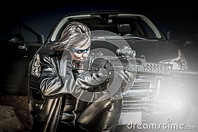 Fire, Dangerous woman dressed in black latex, armed with gun. co Stock Photo