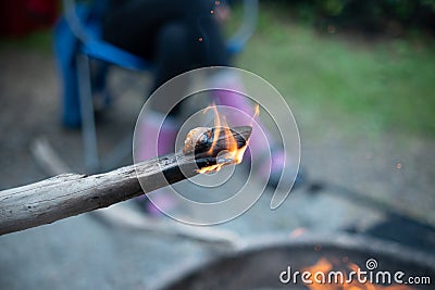 Fire on the edge of a poking stick camping campfire Stock Photo