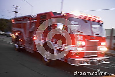 Fire engine driving down street Stock Photo