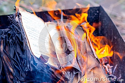 Fire engulfs the pages of an open book. Burning a book Stock Photo