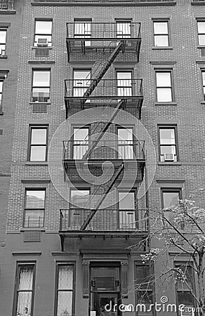 Fire escape stairway on exterior of red brick walkup apartment building Stock Photo