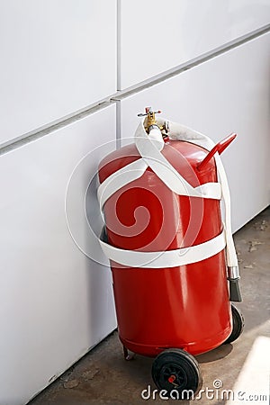 Fire extinguisher near the wall, fire extinguishing equipment and tools, safety measures at gas stations, fire hazard prevention, Stock Photo