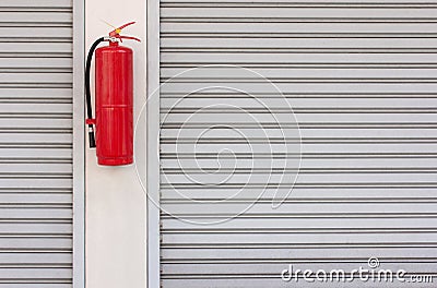 Fire extinguisher on the shutter door Stock Photo