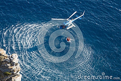 Fire fighter helicopter collect water over the sea Stock Photo