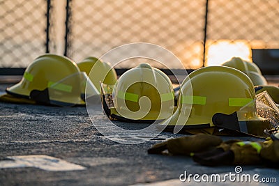 Fire fighting helmets are drying on the navy ship deck after use. Safety net has seen as a background. orange sky between sunset p Stock Photo