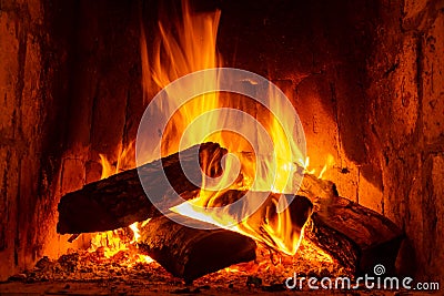 Fire in a fireplace with logs and flames creating a sense of warmth and coziness Stock Photo