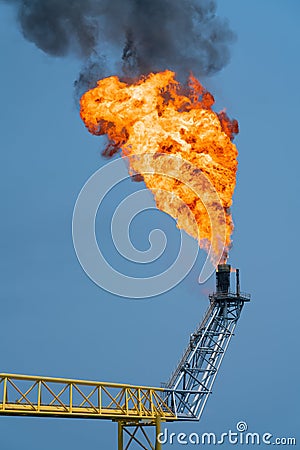 Fire on flare stack at offshore oil and gas central processing platform while burning toxic and release over pressure. Stock Photo