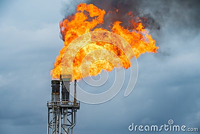 Fire on flare stack at oil and gas central processing platform while burning toxic and release over pressure from process Stock Photo