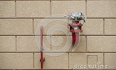 Fire hydrant on brick wall for ceasing fire outdoors building Stock Photo