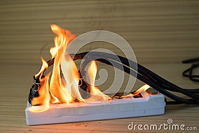 fire multi socket with the connected power strip with a bunch of plugs on wood background Stock Photo