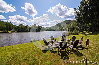 A fire pit surrounded by adirondack chairs next to the Allegheny river in Warren county, Pennsylvania, USA Stock Photo