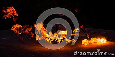 Fire solo performer perform night show with huge burning flames in darkness outdoors, flaming Stock Photo