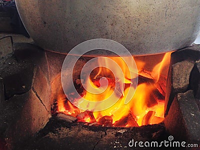 The fire in the stove heats the pot on top. Stock Photo