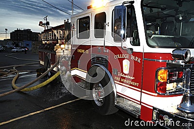 A fire truck has hoses attached at a building fire Editorial Stock Photo