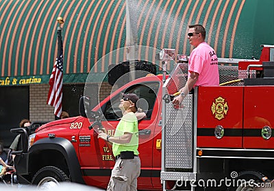 Fire trucks with firemen in a parade in small town America Editorial Stock Photo