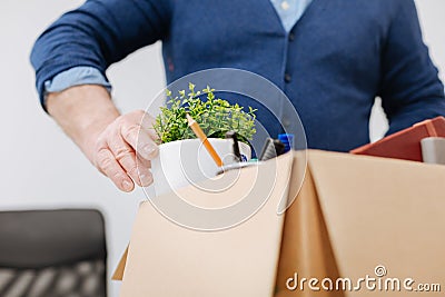 Fired office worker gathering personal belongings into the box Stock Photo