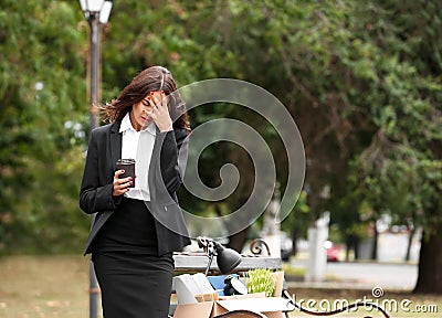 Fired office worker with personal stuff and coffee in park Stock Photo