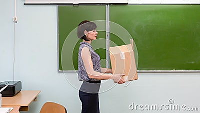 Fired sad teacher leaves school office with a box Stock Photo