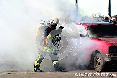Firefighter and burning car Stock Photo