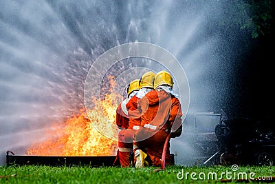 Firefighter Concept. Fireman using water and extinguisher to fighting with fire flame. firefighters fighting a fire with a hose an Stock Photo