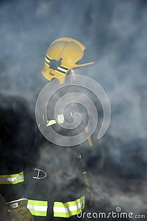 Firefighter in a dark and smoke filled building Editorial Stock Photo