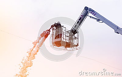 Firefighter extinguishes fire from the lifting crane Stock Photo