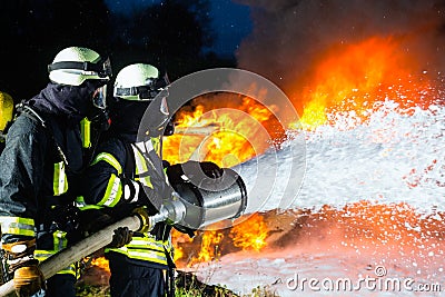 Firefighter - Firemen extinguishing a large blaze Stock Photo