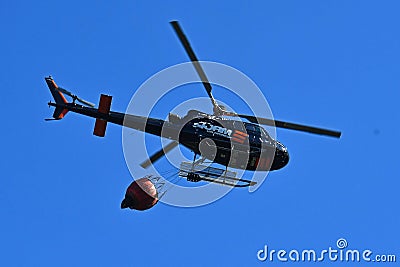 Firefighter helicopter during the rescue operation collects water in Editorial Stock Photo