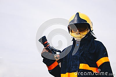 Firefighter holding fire hoses in uniform and an oxygen mask Editorial Stock Photo