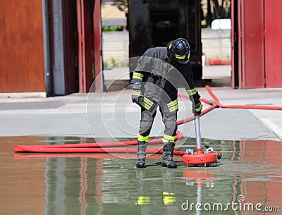 Firefighter positions a powerful fire hydrant Stock Photo