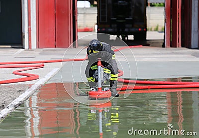 Firefighter positions a powerful fire hydrant Stock Photo