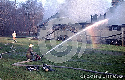 Firefighter pour water on a building on fire Editorial Stock Photo