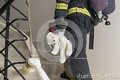 Firefighter rescued a teddy bear child, side view Stock Photo