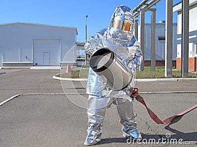 A firefighter in a shiny heat-reflecting suit for fire protection. Stock Photo