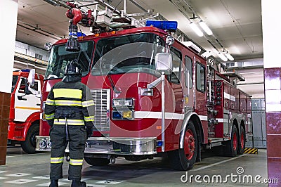A firefighter in special clothes stands in front of a fire truck Stock Photo