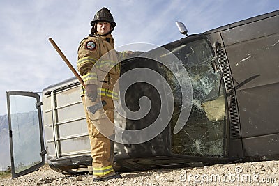 Firefighter Standing By Crashed Car Stock Photo