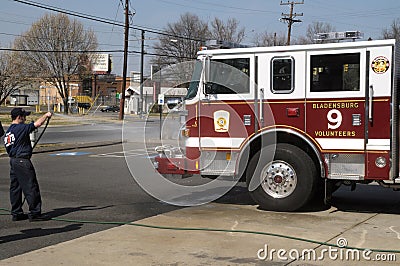 A firefighter washes the fire truck off gf Editorial Stock Photo