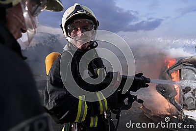 Firefighters fight the fire flame to control fire not to spreading out. Firefighter industrial and public safety concept Stock Photo