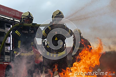 Firefighters fight the fire flame to control fire not to spreading out. Firefighter industrial and public safety concept Stock Photo