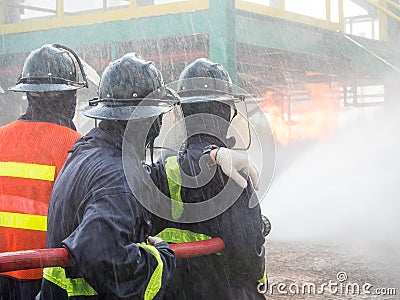 Firefighters fighting fire with pressured water during training exercise. Editorial Stock Photo