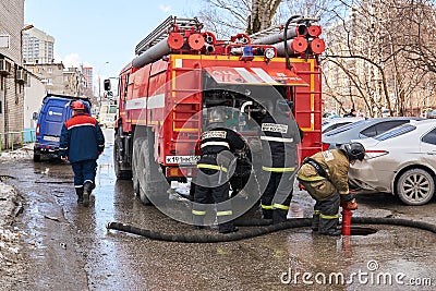 Firefighters of the Ministry for Emergency Situations of the Russian Federation use a fire hydrant next to the fire truck Editorial Stock Photo