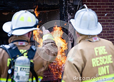 Firefighters pointing to flame Stock Photo