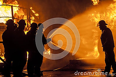 Firefighters spraying burning structure with water Editorial Stock Photo