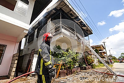 Firefighters of the Surinamese fire brigade extinguish a burning house in the center of Paramaribo, Suriname, South America Editorial Stock Photo