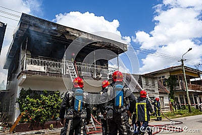 Firefighters of the Surinamese fire brigade extinguish a burning house in the center of Paramaribo, Suriname, South America Editorial Stock Photo