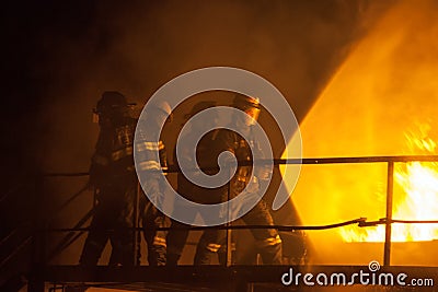 Firefighters using full spray to put out a fire during firefighting exercise Editorial Stock Photo