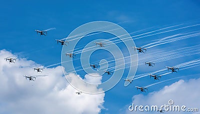 Firefly drones maneuvering through the sky, creating trails while demonstrating precise coordinated movement above the clouds Stock Photo