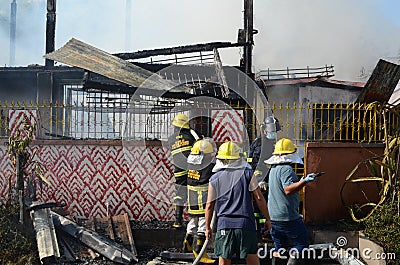 Firemen and volunteers working extinguishing fire on a subdivision house Editorial Stock Photo